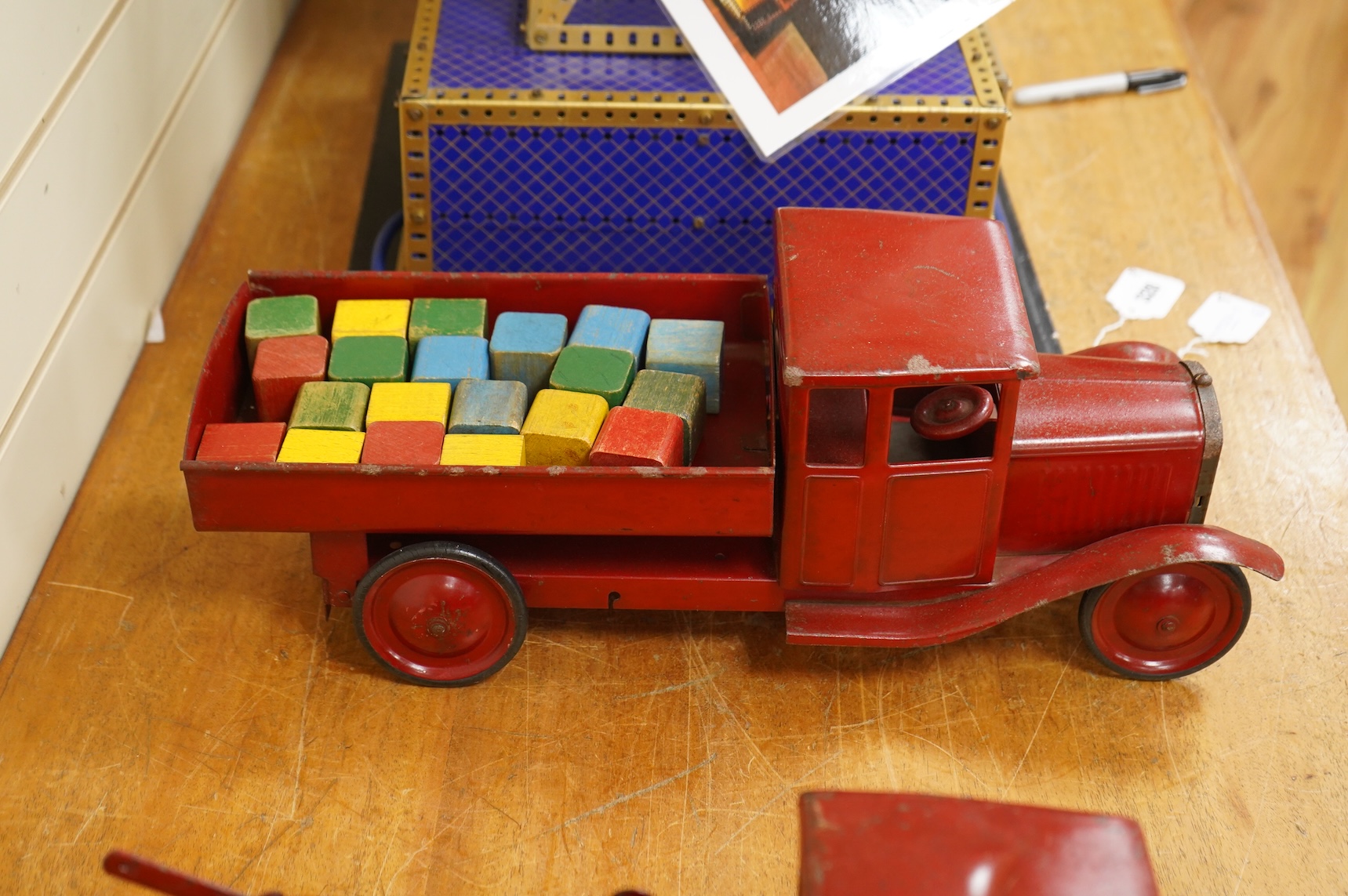 Two 1930's/40's Tri-ang large scale tinplate trucks, both with similar frames and cabs, one as a wreck truck with mounted crane, the other has a wagon with painted wooden blocks, each approximate 44cm long